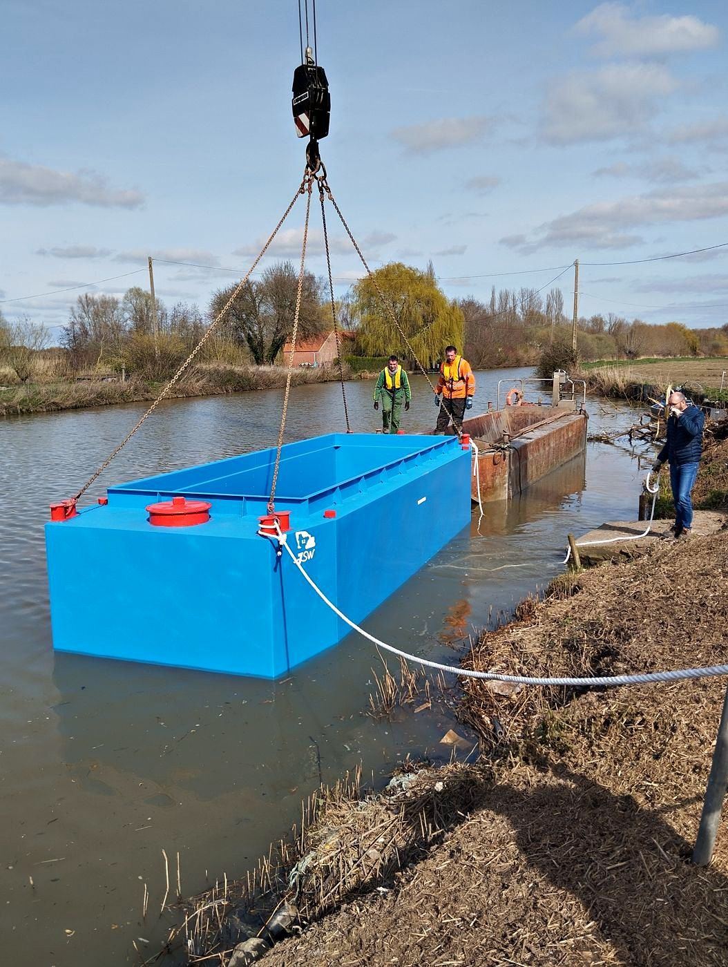 Mise à l'eau d'une barge par l'équipe