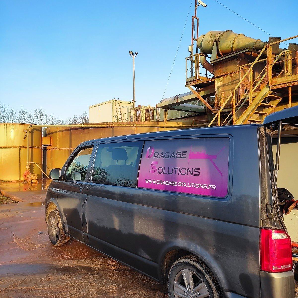 Fourgon Dragage Solutions au pied d'une installation de traitement de sable